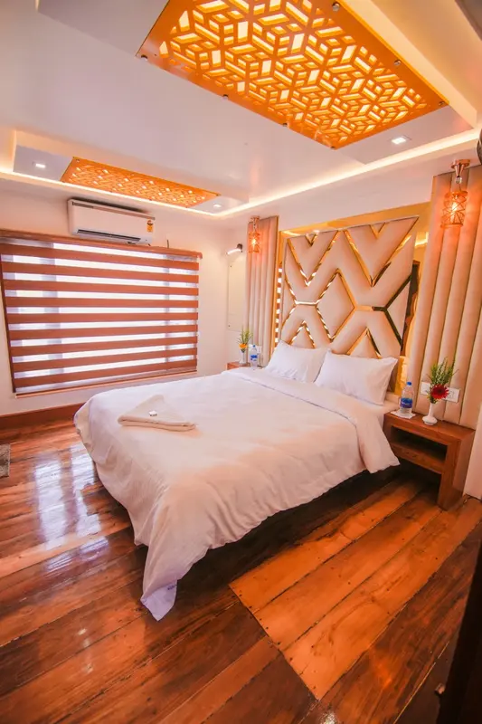 Luxury houseboat bedroom with gold lattice ceiling and premium bedding