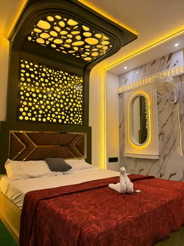 Romantic houseboat bedroom with rose bedspread and warm gold lighting